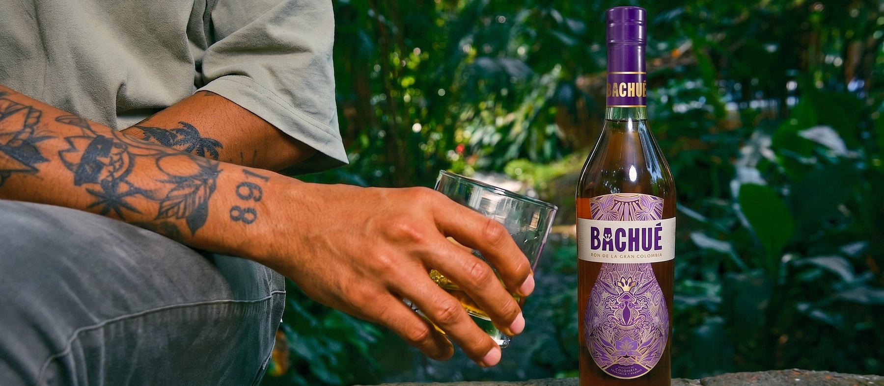 Bachué — bouteille et verre dans un jardin tropical